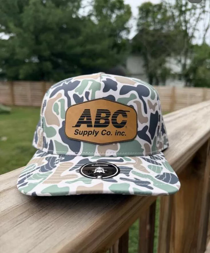 Jungle camo hat with a saddle tan leatherette ABC Supply patch